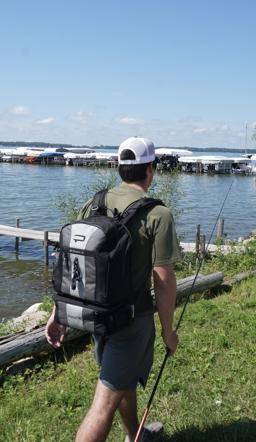 Tyler, founder of Bait Makers United, walking the shoreline with a fishing rod